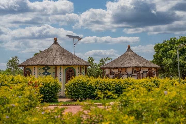 Traditional thatched-style lodges surrounded by colourful gardens