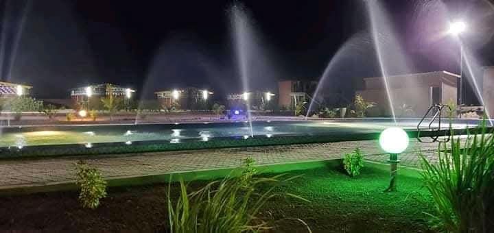Illuminated outdoor grounds and water features at night