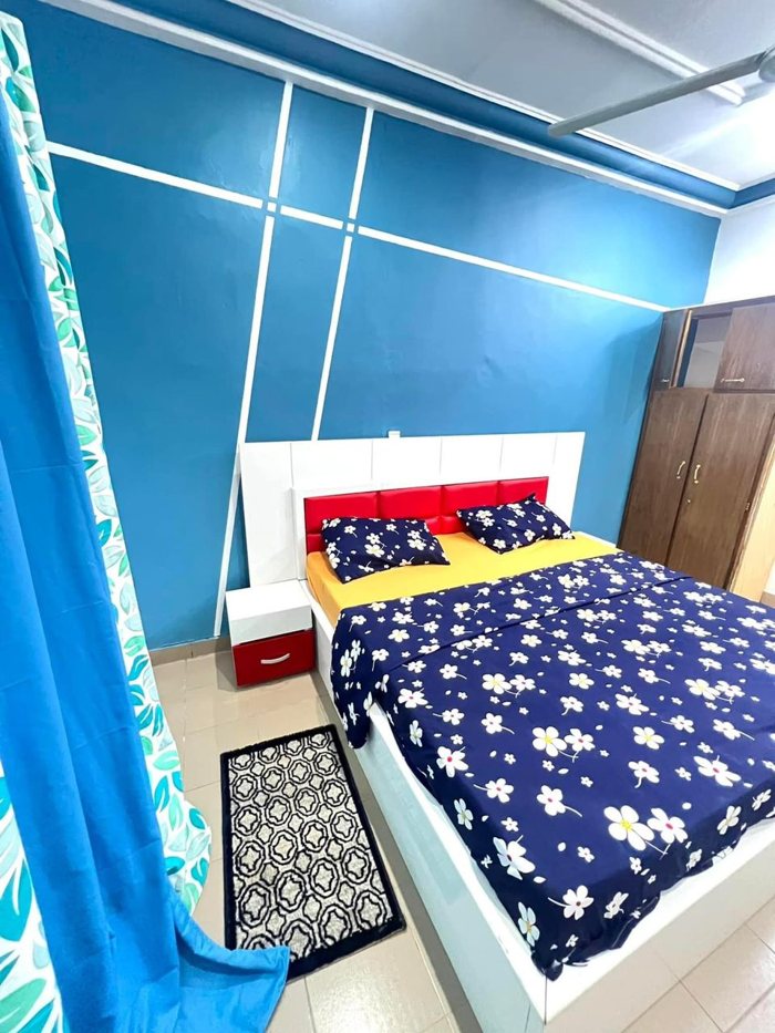 Double bed and bedside furniture in a blue-walled villa bedroom
