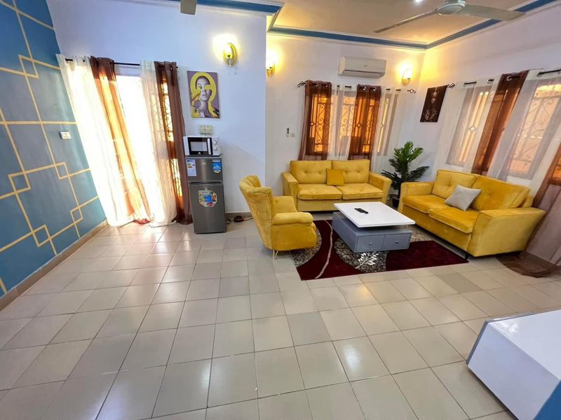 Furnished villa lounge with yellow sofas and tiled flooring