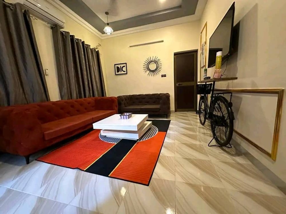 Warmly lit villa lounge with a sofa, television and furnished seating area