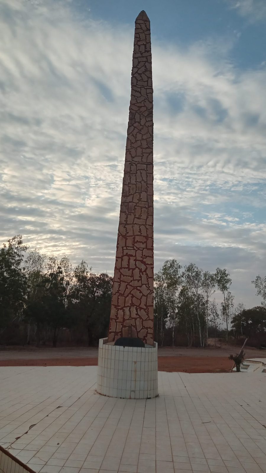 Memorial obelisk beneath a wide Burkina Faso sky